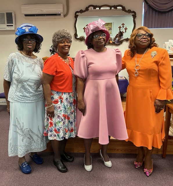 Four women in colorful dresses