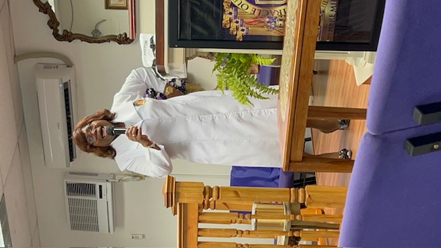 Woman in white robe speaking